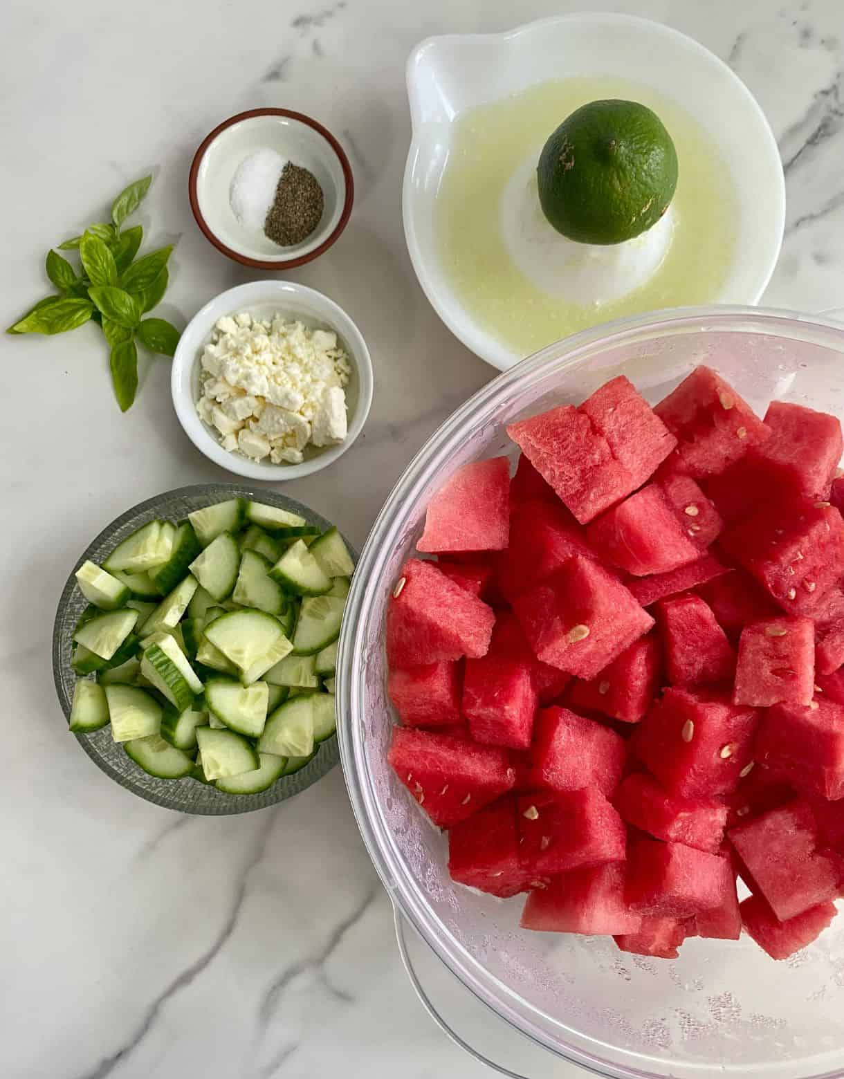 Chopped watermelon, diced cucumber, crumbled feta cheese, a few sprigs of basil, lime juice, salt and pepper.