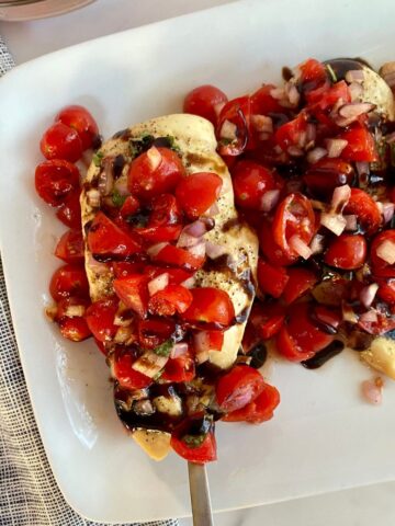 A platter of prepared Sheet Pan Bruschetta Chicken.
