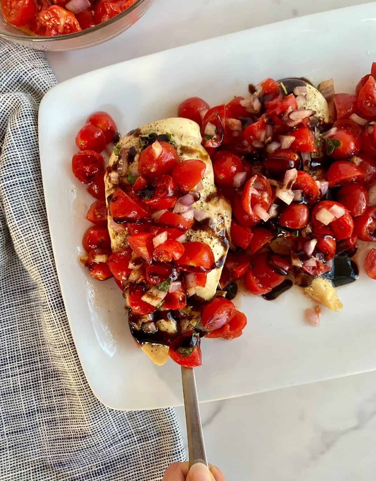 A platter of prepared Sheet Pan Bruschetta Chicken.