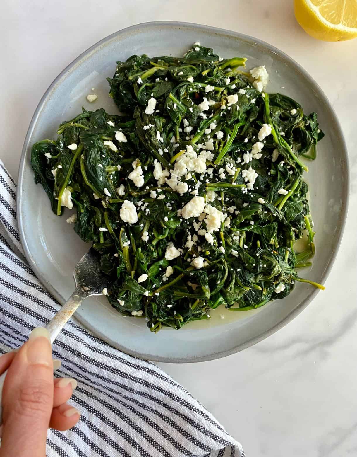 A plate of cooked spinach and feta.