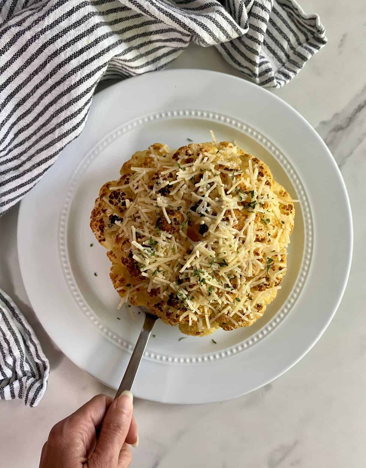 A cooked head of Whole Roasted Cauliflower with Cheese.