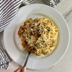 A cooked head of Whole Roasted Cauliflower with Cheese.
