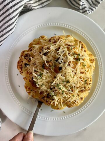 A cooked head of Whole Roasted Cauliflower with Cheese.