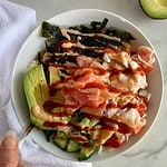 A Deconstructed Sushi Bowl with cauliflower rice, crab, avocado, cucumbers, seaweed, pickled ginger and sriracha mayo.
