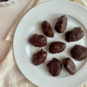 A plate of chocolate covered dates.