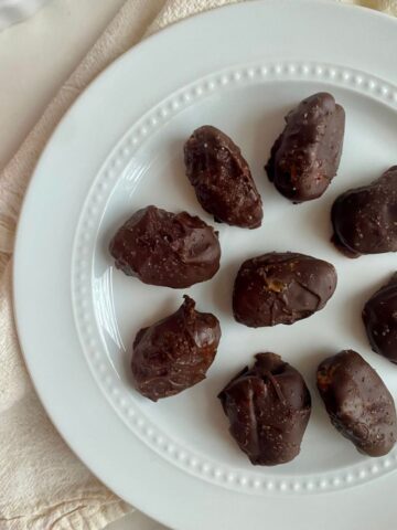 A plate of chocolate covered dates.