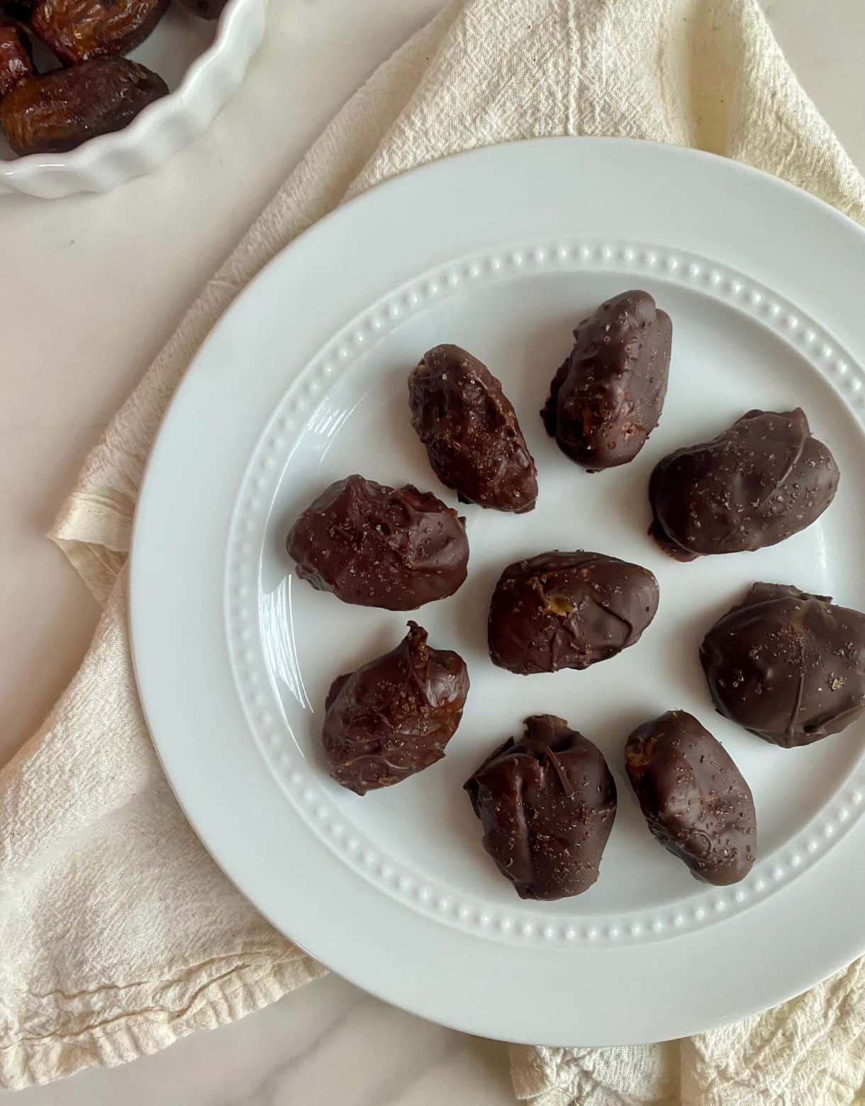 A plate of chocolate covered dates.