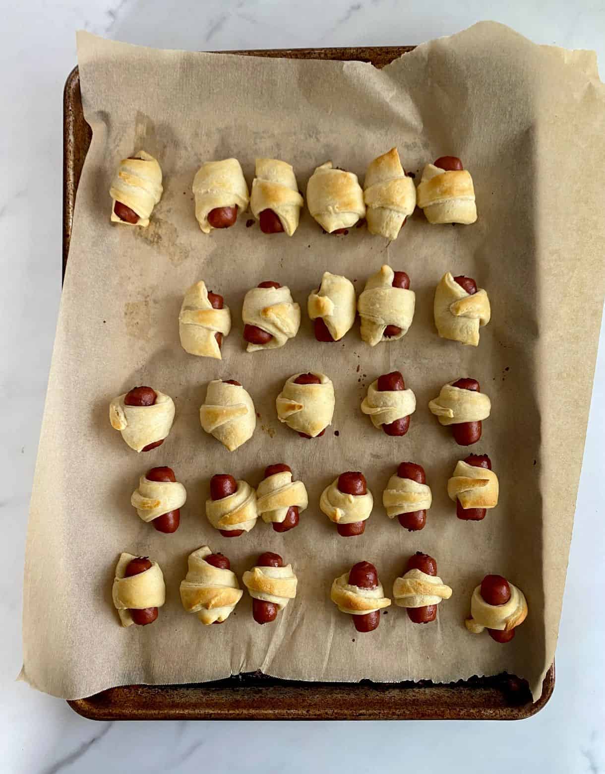 A tray of baked pigs in a blanket.