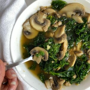 A bowl of Turkey Sausage and Kale Soup with a spoon.
