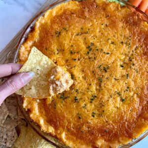 A dish of cooked Cottage Cheese Buffalo Chicken Dip with chips and veggies for dipping.