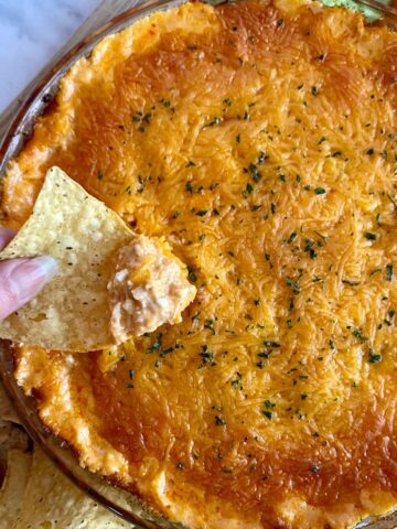A dish of cooked Cottage Cheese Buffalo Chicken Dip with chips and veggies for dipping.