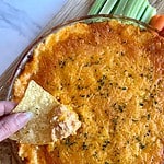 A dish of cooked Cottage Cheese Buffalo Chicken Dip with chips and veggies for dipping.