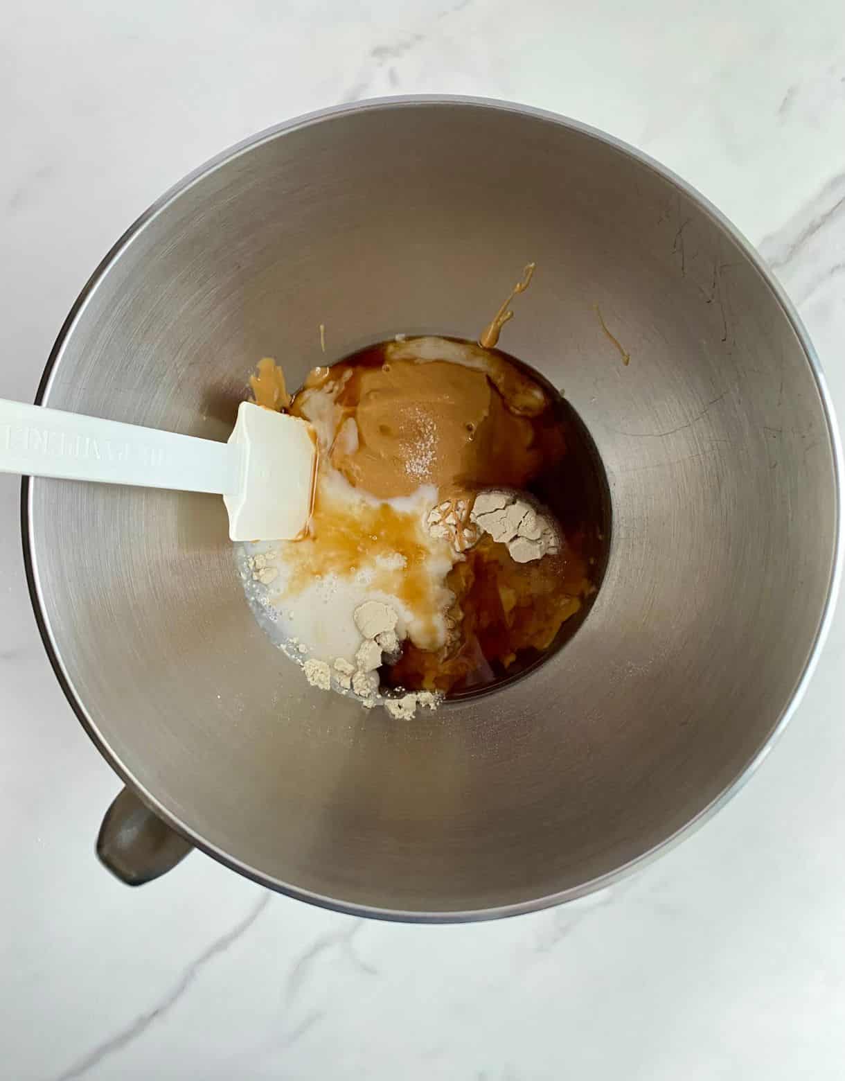 A mixing bowl with ingredients added but not yet stirred.