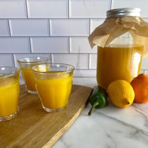 A jar of Immunity Shots plus three shots poured into small glasses.