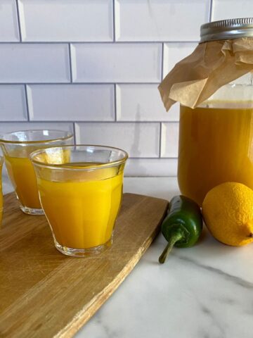 A jar of Immunity Shots plus three shots poured into small glasses.