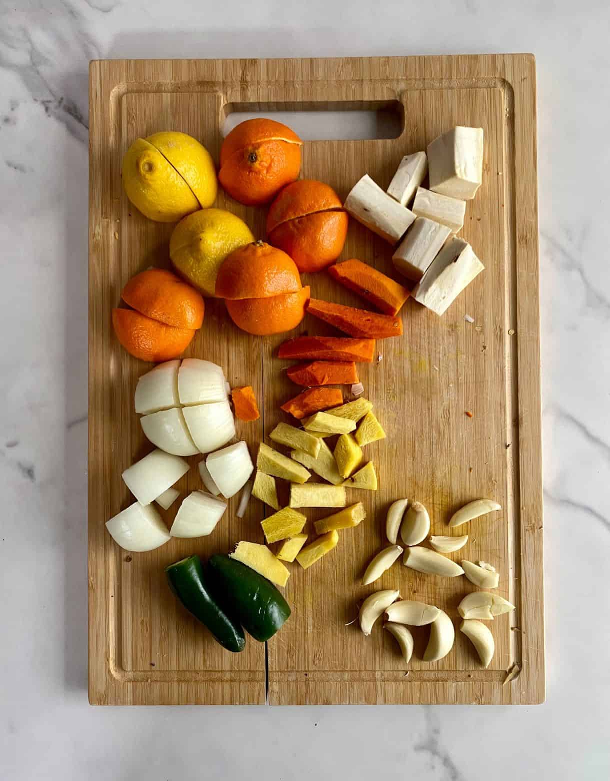 Onion, jalapenos, lemon, oranges, garlic, turmeric root, ginger root and horseradish root all peeled, chopped and prepped.