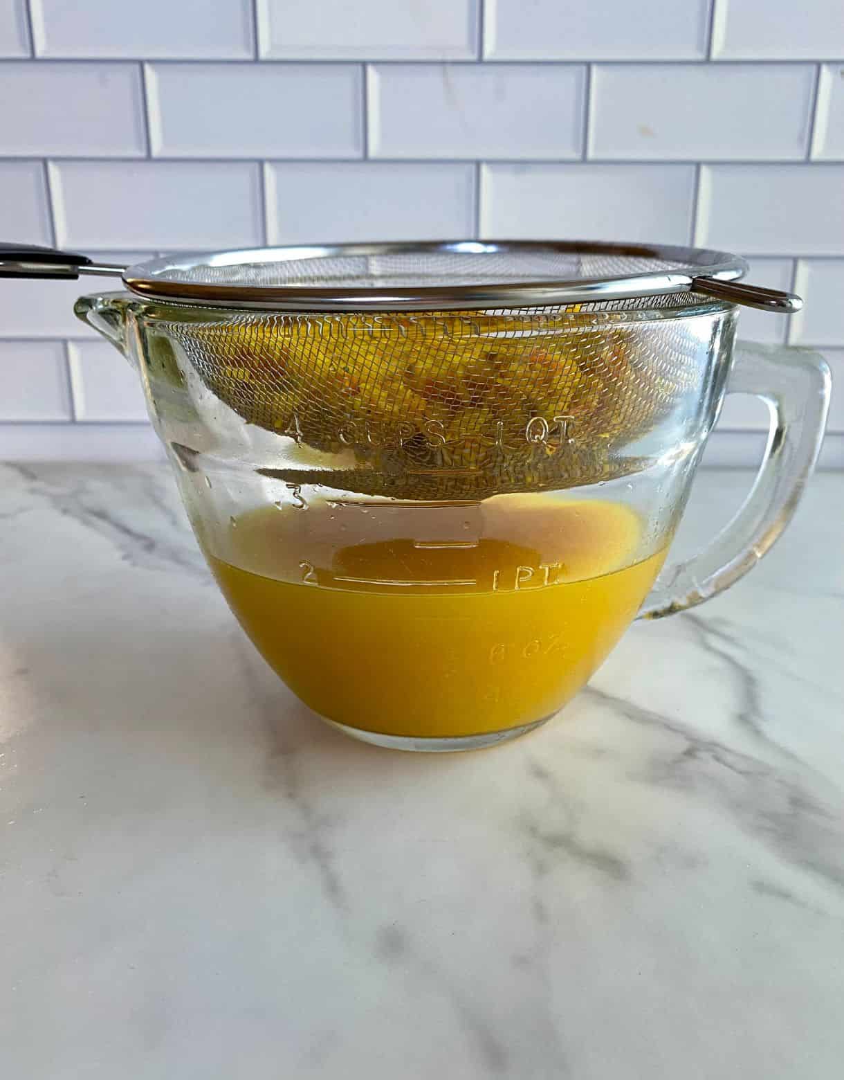 Pulp being strained out of immunity shot liquid.