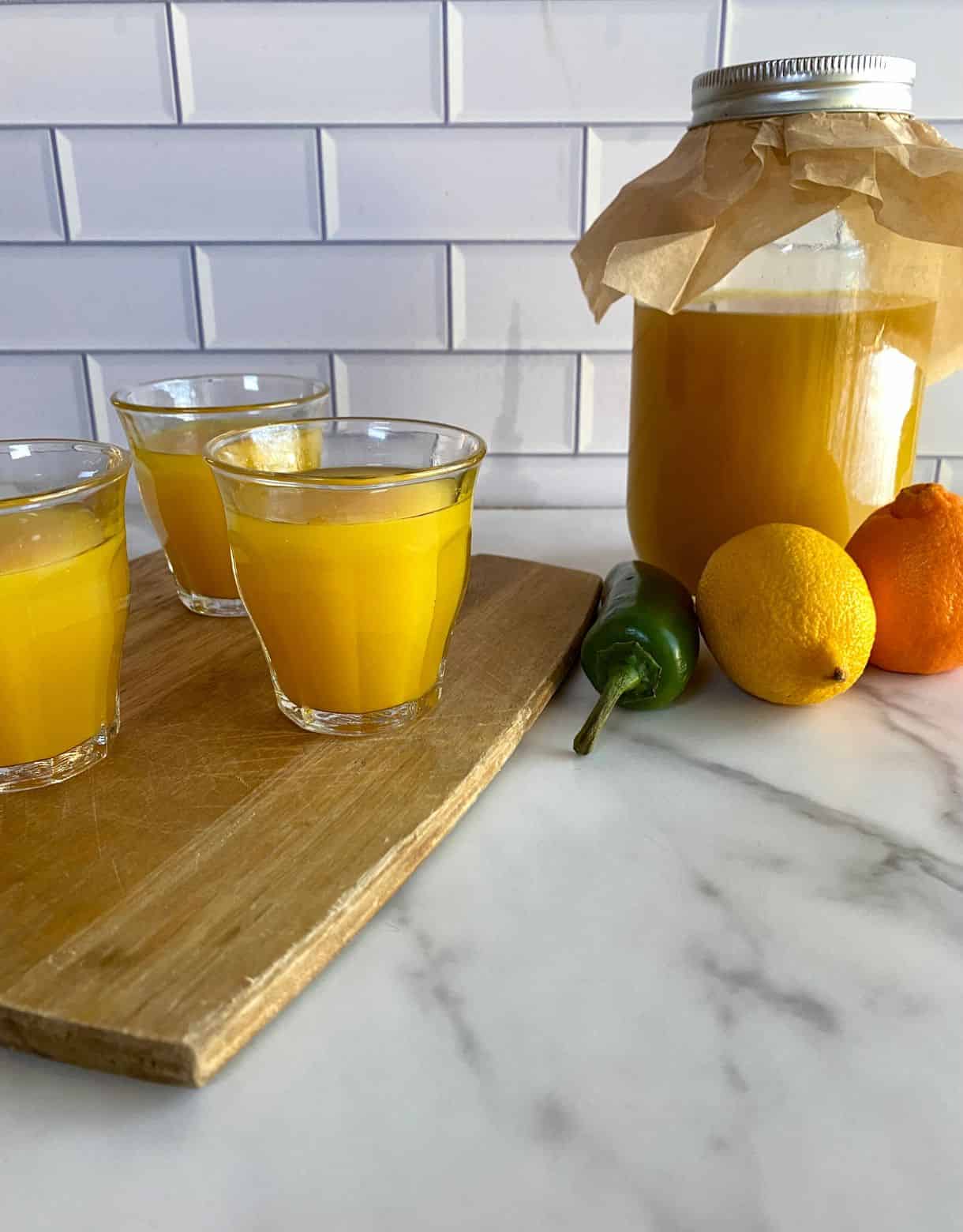 A jar of Immunity Shots plus three shots poured into small glasses.