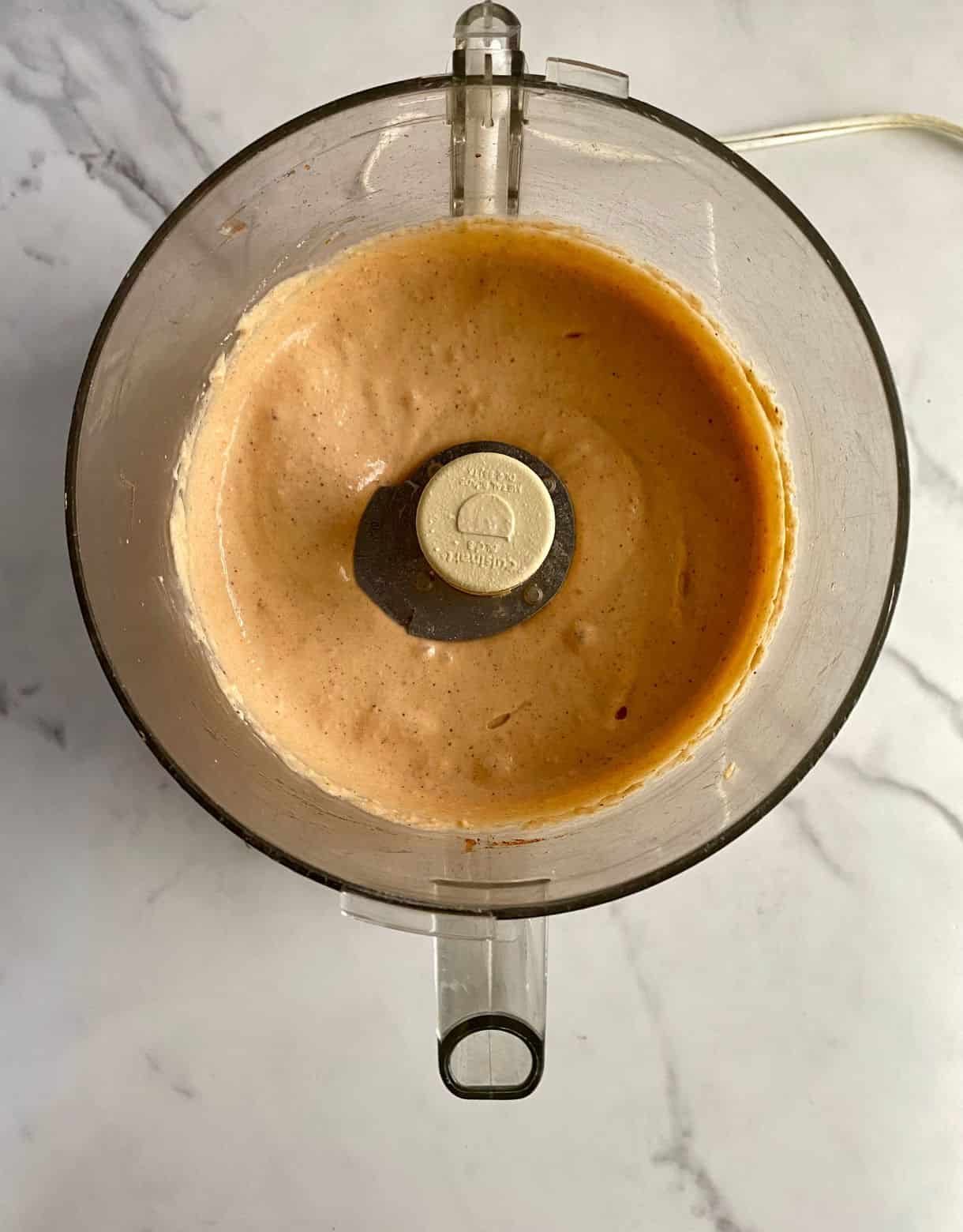 A food processor with blended queso.