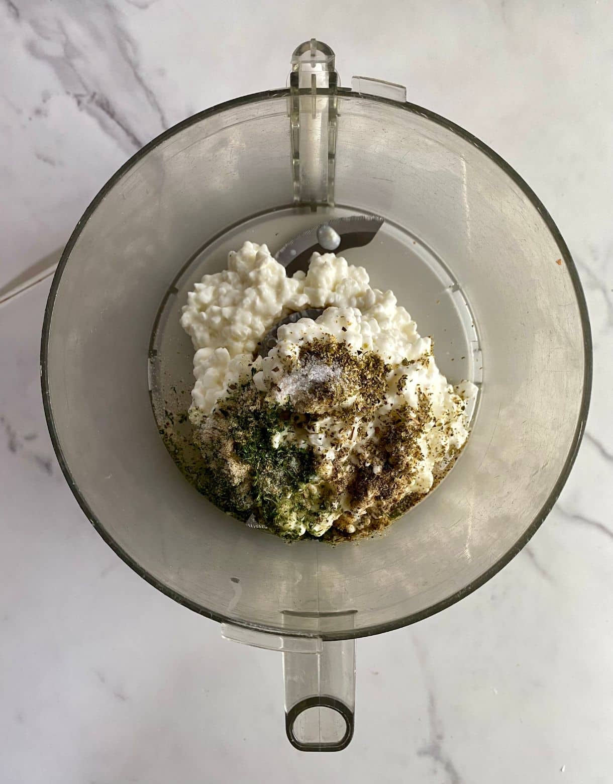 A food processor with cottage cheese, spices and vinegar added.