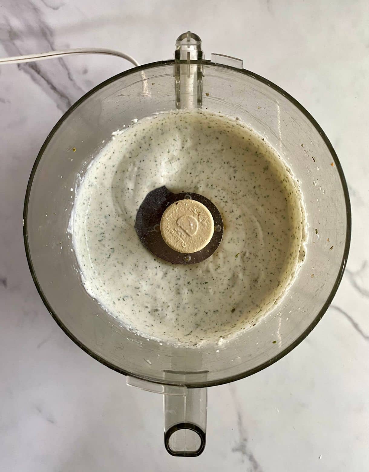 A food processor with finished blended Cottage Cheese Ranch.