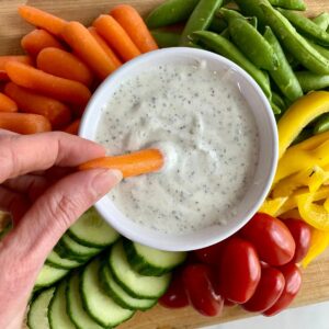 A bowl of Cottage Cheese Ranch surrounded by veggies.