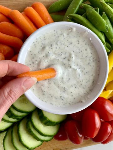 A bowl of Cottage Cheese Ranch surrounded by veggies.