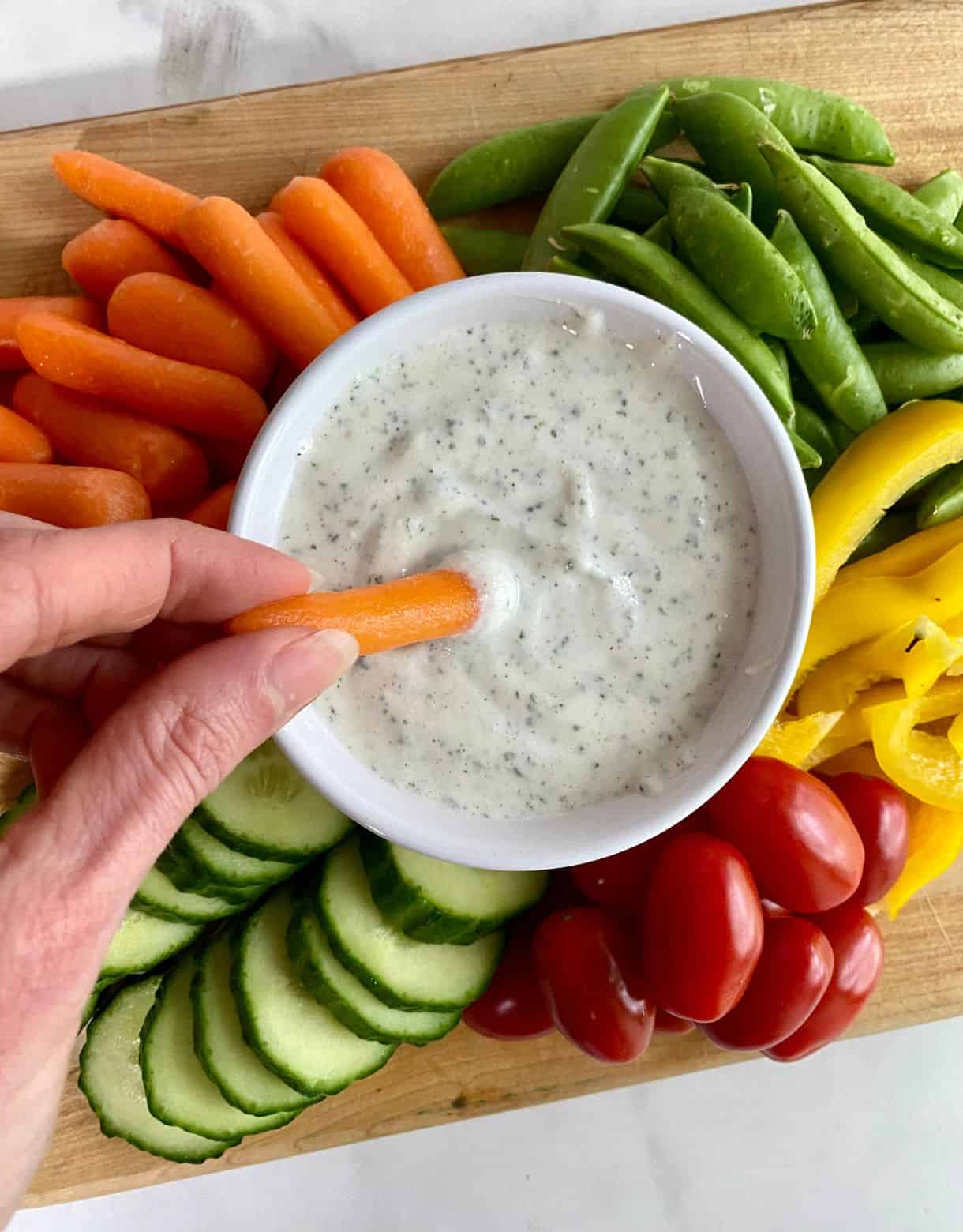 A bowl of Cottage Cheese Ranch surrounded by veggies.